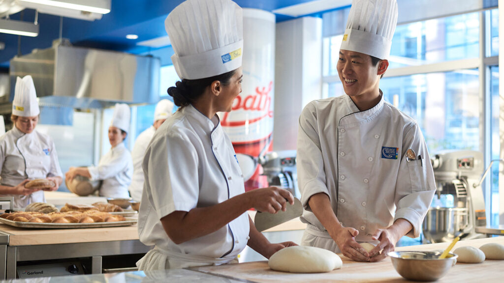 Students preparing fresh bread and pastry products during hands-on baker training at Apex Community College.
